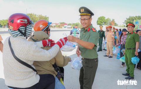 Về quê ăn Tết, bất ngờ thấy công an gọi vào, ngờ đâu được tặng quà- Ảnh 3. Trên đường về quê đón Tết, người dân bất ngờ được bộ đội, công an, đoàn viên thanh niên, phụ nữ... huyện Thuận Nam mời vào tặng quà - Ảnh: DUY NGỌC
