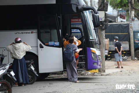 TP.HCM: Nhiều xe khách vẫn thập thò đón khách ở cây xăng, quán nước- Ảnh 1. Xe khách Hoàng Yến bất chấp quy định vẫn đón nhiều khách tại cây xăng trên quốc lộ 13, sáng 5-2 - Ảnh: MINH HÒA