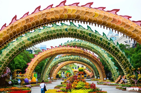 Ba linh vật rồng trên đường hoa Nguyễn Huệ khoe dáng- Ảnh 12. Khung cảnh đuôi rồng ôm lấy đường hoa, tạo chiều sâu và nét rực rỡ của đường hoa.