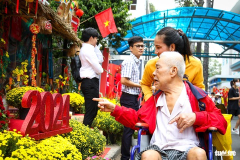 Ở đường hoa Bệnh viện Chợ Rẫy có Tết, có tình thương- Ảnh 5. Chị Như Thủy (quê Vĩnh Long) đẩy xe cùng cha dạo quanh đường hoa - Ảnh: PHƯƠNG QUYÊN