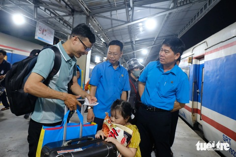 Hàng chục ngàn lao động về quê ăn Tết trên những chuyến tàu, chuyến xe mùa xuân- Ảnh 3. Lãnh đạo Liên đoàn Lao động TP.HCM đến tiễn gia đình công nhân về quê ăn Tết tại ga Sài Gòn tối 4-2 - Ảnh: VŨ THỦY