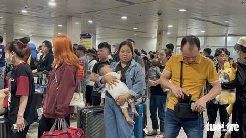 Nhờ đâu Tân Sơn Nhất bỗng thông thoáng, chuyến bay delay giảm?- Ảnh 4. Trẻ em, người lớn tuổi khi tới sân bay nhanh chóng liên hệ nhân viên hãng bay, nhân viên mặt đất để được hỗ trợ lối làm thủ tục riêng hoặc được ưu tiên - Ảnh: CÔNG TRUNG