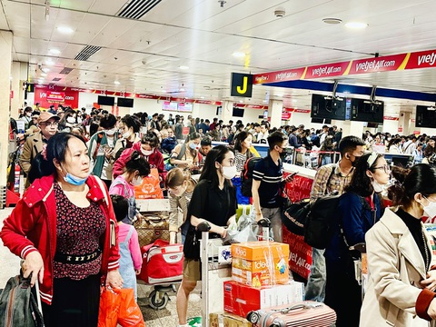 Bay Tết: Dưới đất đã ổn, chỉ lo ông Trời- Ảnh 1. Khách xếp hàng dài trật tự chờ vào lối làm thủ tục check-in ở quầy Vietjet - Ảnh: CÔNG TRUNG