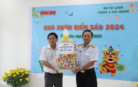 Quà xuân biển đảo của bạn đọc Tuổi Trẻ đến tay chiến sĩ Vùng 5 Hải quân- Ảnh 1. Chuẩn đô đốc Nguyễn Duy Tỷ nhận "Quà xuân biển đảo" do nhà báo Hoàng Trí Dũng, trưởng Văn phòng đại diện báo Tuổi Trẻ vùng Tây Nam Bộ, trao tặng - Ảnh: CHÍ QUỐC
