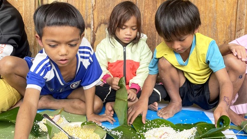 Mang Tết lên núi cho trẻ em nghèo- Ảnh 1. Những đứa trẻ ở vùng núi Quảng Nam lần đầu tiên được dạy và mày mò tự gói bánh chưng - Ảnh: BÌNH NAM