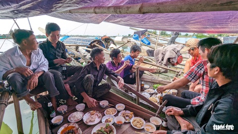 Mộng lên bờ của phận vạn đò trên đầm phá Tam Giang- Ảnh 6. Xóm vạn đò nhỏ trên phá Tam Giang cùng ngồi lại với nhau sau một năm đánh bắt cá tôm để chúc nhau sớm hoàn thành ước nguyện “lên bờ” - Ảnh: NHẬT LINH