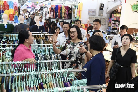 Ngày 27 Tết: siêu thị và chợ đầy ắp hàng hóa, giá tốt- Ảnh 1. Thứ trưởng Phan Thị Thắng trao đổi về hàng hóa Tết với tiểu thương chợ Bến Thành sáng 6-2 - Ảnh: TỰ TRUNG