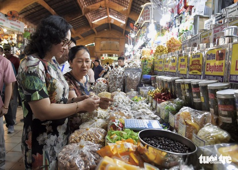 Ngày 27 Tết: siêu thị và chợ đầy ắp hàng hóa, giá tốt- Ảnh 2. Thứ trưởng Bộ Công Thương tìm hiểu về các sản phẩm quầy mứt, bánh kẹo... là mặt hàng bán chạy nhất tại chợ Bến Thành hiện nay - Ảnh: TỰ TRUNG