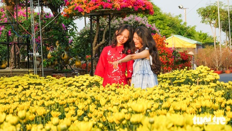 Chở thuê mùa xuân, người lao động nghèo đất biển Kiên Giang có tiền ăn Tết- Ảnh 3. Các bạn trẻ mặc áo mới đi đến các điểm chợ hoa xuân TP Rạch Giá chụp ảnh Tết - Ảnh: CHÍ CÔNG