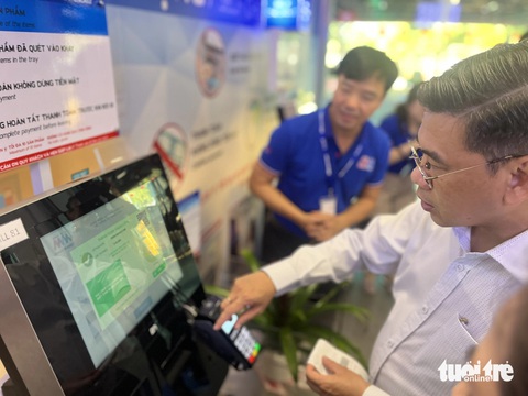 Khách sắm Tết tính tiền tự động ở siêu thị- Ảnh 1. Phó chủ tịch UBND TP.HCM trải nghiệm thanh toán tự động ở siêu thị ngày 6-2 - Ảnh: N.BÌNH