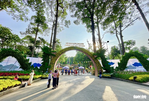Ngàn người trẩy hội hoa xuân TP.HCM, xúng xính váy áo chụp ảnh- Ảnh 3. Tại cổng chính của công viên Tao Đàn (trên đường Trương Định) là hình ảnh đôi lưỡng long bên cạnh nền hoa rực rỡ - Ảnh: CHÂU TUẤN