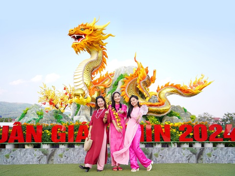 6 đặc trưng của Tết Việt- Ảnh 1. Bạn trẻ chụp ảnh với linh vật rồng tại thị trấn Lao Bảo, huyện Hướng Hóa (Quảng Trị) - Ảnh: NGỌC LÂN