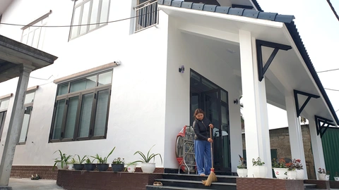 Tăng Duy Tân trong mắt người dân quê nhà: Nổi tiếng vẫn cởi áo phụ hồ xây nhà cho cha mẹ- Ảnh 1. Bà Hoàng Thị Bé, mẹ của Tân, bên ngôi nhà khang trang Tân vừa xây cho cha mẹ ở quê nhà - Ảnh: QUỐC NAM