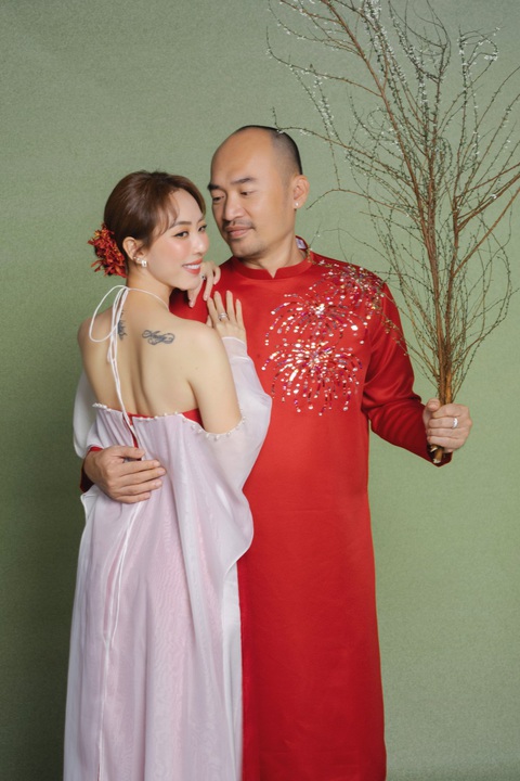 Thu Trang - Tiến Luật tiết lộ kế hoạch Tết ở sân khấu kịch- Ảnh 1. Thu Trang mặc áo dài cách điệu, khoe vai trần gợi cảm bên ông xã Tiến Luật trong bộ ảnh đón Tết