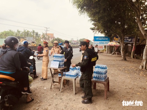 Cảnh sát giao thông phát nước, khăn lạnh miễn phí cho người dân về quê ăn Tết- Ảnh 3. Cảnh sát giao thông phát nước suối, khăn lạnh miễn phí cho người dân trên quốc lộ 1 - Ảnh: HOÀI THƯƠNG