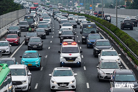 Người dân rời Hà Nội về quê nghỉ Tết, ùn tắc ở các cửa ngõ, mưa rét gây thêm khó khăn- Ảnh 1. Xe ô tô lấn vào làn khẩn cấp do ùn tắc, chiếc xe cứu thương phải len lỏi tìm lối thoát khỏi cao tốc Pháp Vân trong chiều 7-2 - Ảnh: HỒNG QUANG