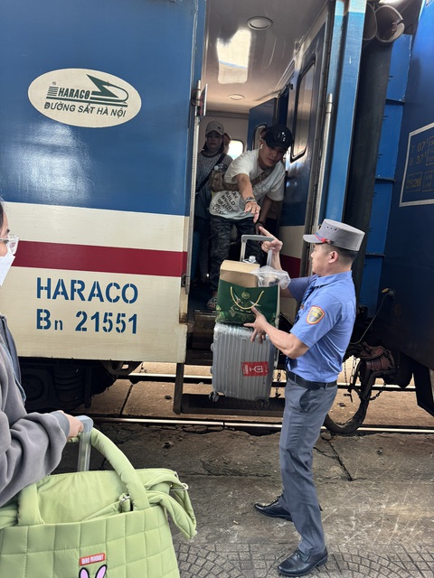 Ngày cao điểm, hành khách bất ngờ với tàu Tết- Ảnh 5. Nhân viên tàu SE6 hỗ trợ hành khách xuống ga Đà Nẵng ngày 6-2 - Ảnh: CÔNG DŨNG