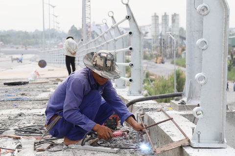 Cần Thơ lý giải nguyên nhân chưa đưa cầu 800 tỉ vào khai thác dịp Tết- Ảnh 2. Công nhân đang thi công những hạng mục phụ của cầu Trần Hoàng Na trong những ngày giáp Tết - Ảnh: CHÍ QUỐC