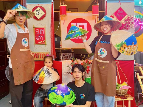 Mang niềm vui ngày Tết qua những nét vẽ- Ảnh 2. Anh Chiến cùng với các thành viên trong nhóm vẽ nón - Ảnh: THANH CHƯƠNG