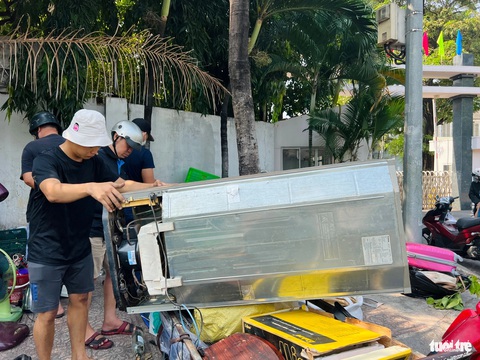 Nhộn nhịp săn đồ lạc xoong cận Tết, từ cái nồi cho đến đôi giày- Ảnh 8. Chở tủ lạnh cũ ra bán cho chủ hàng lạc xoong - Ảnh: YẾN TRINH