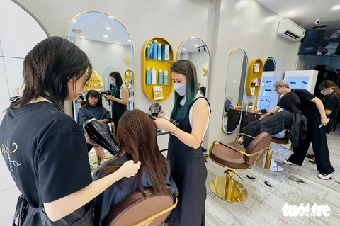 Hối hả chi chục triệu làm tóc, sắm áo dài trước giờ tiệm nghỉ Tết- Ảnh 1. Nhiều khách tranh thủ làm tóc trước khi tiệm chính thức nghỉ Tết vào hôm nay - Ảnh: BÔNG MAI