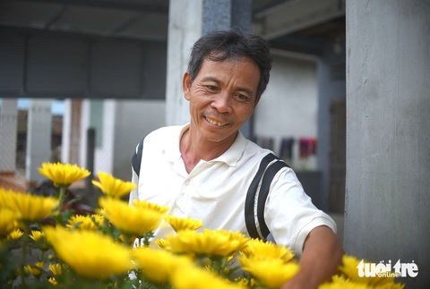 Ông Phan Văn Ta - ba của bé Ca vui vẻ khoe chậu hoa cúc của gia đình đón Tết năm nay - Ảnh: LÂM THIÊN Ông Phan Văn Ta - ba của bé Ca - vui vẻ khoe chậu hoa cúc của gia đình đón Tết năm nay - Ảnh: LÂM THIÊN