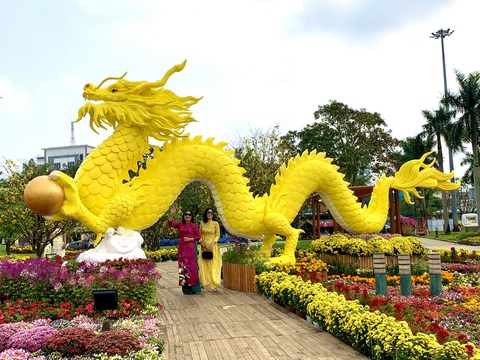 Công nhân canh giữ cặp rồng vàng Quảng Nam giữa rừng hoa Tết- Ảnh 1. Nhiều người dân Tam Kỳ tranh thủ chụp ảnh với linh vật rồng vàng ngay sau khi vừa được hoàn thiện tại quảng trường 24-3 - Ảnh: TRẦN HUỲNH