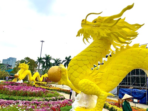 Công nhân canh giữ cặp rồng vàng Quảng Nam giữa rừng hoa Tết- Ảnh 3. Các công nhân đứng cạnh rồng vàng để nhắc nhở người dân không sờ vào linh vật được làm bằng xốp - Ảnh: TRẦN HUỲNH