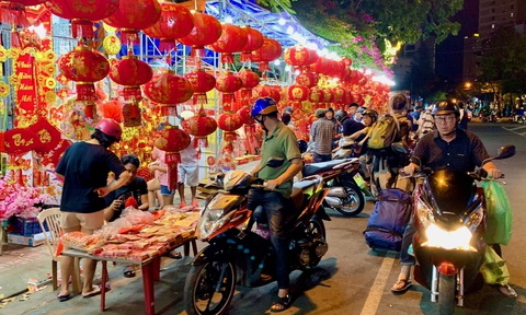Xúng xính áo mới với đường hoa đêm giao thừa- Ảnh 13. Tại các tuyến phố người dân, du khách tranh thủ mua thêm bao lì xì, đèn lồng về trang trí Tết - Ảnh: THY KHUÊ
