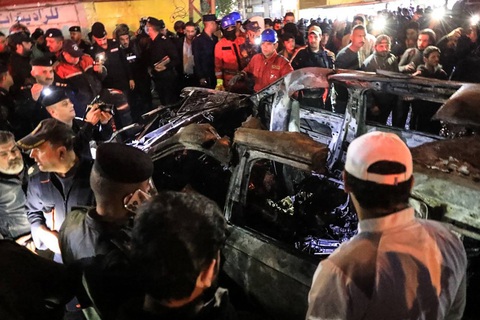 Iraq chỉ trích Mỹ ám sát người giữa khu dân cư, gây nguy hiểm- Ảnh 1. Cảnh sát và lực lượng an ninh Iraq vây quanh hiện trường vụ không kích bằng máy bay không người lái (drone) của Mỹ vào một ô tô khiến ba người chết, trong đó có hai thủ lĩnh của một lực lượng thân Iran tối 7-2 - Ảnh: AFP
