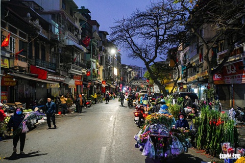 Hà Nội yên bình sáng 30 Tết- Ảnh 2. Từ sớm, phiên chợ trước cổng chợ Đồng Xuân đã ken đặc các gánh hàng - Ảnh: HỒNG QUANG