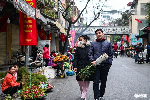 Hà Nội yên bình sáng 30 Tết- Ảnh 6. Nhiều người tranh thủ đi chợ sớm để tận hưởng không khí ngày cuối cùng của năm. Họ mua bán nhanh chóng rồi về nhà để sắp mâm ngũ quả, nấu cơm tất niên - Ảnh: HỒNG QUANG