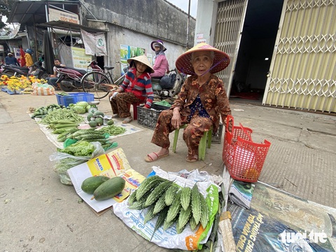 Bãi bồi, ruộng rau ven sông Vu Gia ngày cận Tết đẹp như tranh- Ảnh 3. Những cụ già bán rau quả được hái ở bãi bồi ven sông Vu Gia - Ảnh: LÊ TRUNG