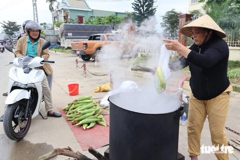Bãi bồi, ruộng rau ven sông Vu Gia ngày cận Tết đẹp như tranh- Ảnh 4. Luộc bắp bán dọc đường - Ảnh: LÊ TRUNG