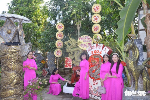 Phố 'Ông Đồ' điểm du xuân lý tưởng, tái hiện Tết xưa ở miền Tây- Ảnh 2. Nhiều chị em phụ nữ mặc áo dài đến phố Ông Đồ để chek-in làm kỷ niệm - Ảnh: HOÀI THƯƠNG