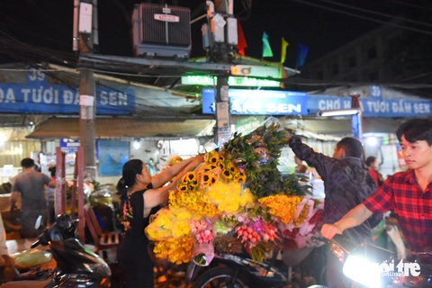 Chợ hoa TP.HCM giảm giá sập sàn mà vẫn không hết hàng- Ảnh 5. Nhiều tiểu thương trong ngày cuối đã chạy nước rút giảm giá mạnh nhưng sức mua vẫn quá yếu - Ảnh: TỰ TRUNG
