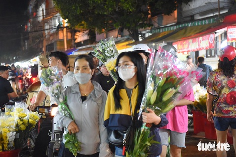Chợ hoa TP.HCM giảm giá sập sàn mà vẫn không hết hàng- Ảnh 6. Các bạn trẻ mua hoa tại chợ hoa Đầm Sen, quận 11, TP.HCM - Ảnh: TỰ TRUNG