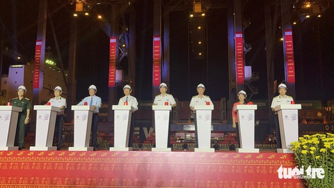 Ngay tối giao thừa, 'mở hàng' xuất khẩu lô hàng linh kiện điện tử hơn trăm ngàn tấn- Ảnh 1. Lãnh đạo TP.HCM cùng lãnh đạo Tổng công ty Tân Cảng Sài Gòn ấn nút phát lệnh làm hàng đầu xuân vào tối 9-2 - Ảnh: N.BÌNH