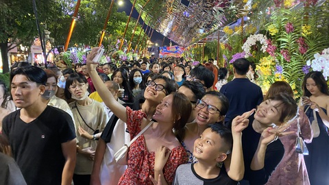 Xúng xính áo mới với đường hoa đêm giao thừa- Ảnh 4. Một gia đình tham quan, chụp hình lưu niệm đường hoa Nguyễn Huệ TP.HCM - Ảnh: TỰ TRUNG