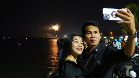 Mãn nhãn pháo hoa giao thừa ba miền Tết Việt- Ảnh 31. Người dân và du khách xem pháo hoa trên khu lấn biển Kiên Giang và lưu lại khoảnh khắc đáng nhớ cùng gia đình - Ảnh: CHÍ CÔNG