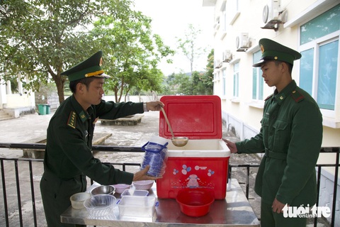 Nồi cháo ấm tiếp sức bệnh nhân của biên phòng La Lay- Ảnh 1. Cán bộ, chiến sĩ Đồn biên phòng cửa khẩu quốc tế La Lay chuẩn bị cháo phát cho bệnh nhân - Ảnh: HOÀNG TÁO