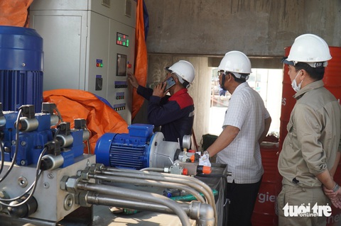 Cống ngăn mặn lớn thứ 2 miền Tây đóng sớm hơn kế hoạch do mặn xâm nhập nhanh- Ảnh 3. Các nhân viên vận hành cống Nguyễn Tấn Thành thao tác đóng cống - Ảnh: MẬU TRƯỜNG