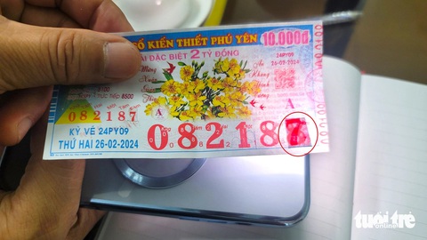 Người bán vé số dạo, đại lý có thể dùng đèn flash của điện thoại di động soi chiếu vào các dãy số trên tờ vé số để phát hiện dấu hiệu giả mạo - Ảnh: NGUYỄN HOÀNG Người bán vé số dạo, đại lý có thể dùng đèn flash của điện thoại di động soi chiếu vào các dãy số trên tờ vé số để phát hiện dấu hiệu giả mạo - Ảnh: NGUYỄN HOÀNG