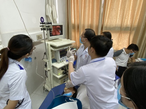 Hóc xương gà 2 năm trong phế quản mà không biết- Ảnh 1. Ê kíp nội soi gắp mảnh xương cho cụ bà - Ảnh: B.V.