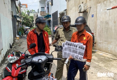 Cả phường ở TP.HCM cùng chung tay bóc quảng cáo dán bậy- Ảnh 3. Lực lượng thuộc phường Thới An đã bắt tận tay một số trường hợp dán vẽ bậy - Ảnh: GIAI THỤY