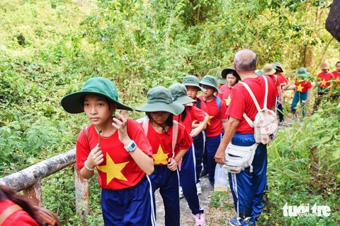 Học sinh Nha Trang khám phá căn cứ Đồng Bò, tập cứu thương như thời chiến- Ảnh 2. Luôn có giáo viên, người hướng dẫn quan sát hướng dẫn các em khi di chuyển - Ảnh: TRẦN HOÀI