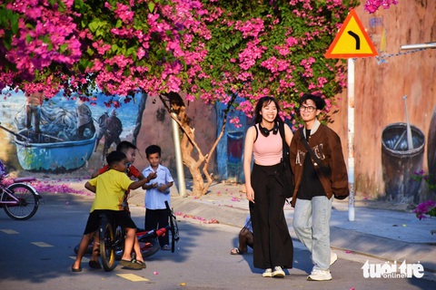 Mê mẩn với hoa giấy, hoa xoài tại Khánh Hòa- Ảnh 1. Du khách thích thú check-in tại đường bích họa phủ đầy hoa giấy ở TP Nha Trang - Ảnh: TRẦN HOÀI