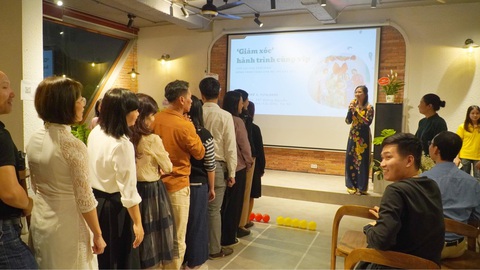 Những người 'leo dốc' cùng trẻ tự kỷ- Ảnh 3. Chị Nguyễn Thị Thu Ngân - thành viên CLB Live Village Coaching - hướng dẫn các cha mẹ tham gia một hoạt động tương tác