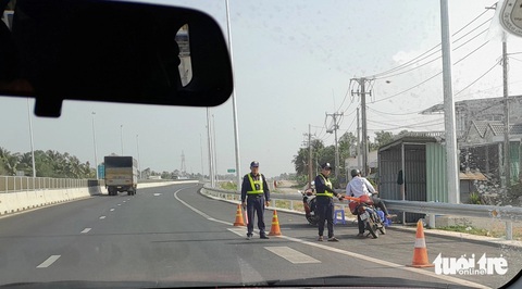 Nhiều người đi xe máy vẫn chạy nhầm vào cao tốc dù có biển cấm- Ảnh 1. Đội tuần tra bảo vệ chặn nhiều xe máy chạy nhầm vào cao tốc - Ảnh: CHÍ HẠNH