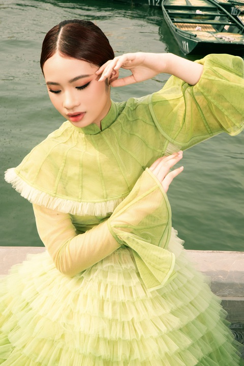 Với thiết kế thứ hai, mẫu nhí Bảo Hà đã mang đến một thiết kế hiện đại hơn với chiếc đầm bồng xòe tone xanh khi thực hiện những shoot ảnh tại hồ nước rộng mênh mông trong quần thể di tích Tam Chúc. Thiết kế Bảo Hà diện trong shoot ảnh này là thiết kế được lấy cảm hứng từ những lá sen và thể hiện với kỹ thuật chuyển màu tinh tế. Với thiết kế thứ hai, mẫu nhí Bảo Hà đã mang đến một thiết kế hiện đại hơn với chiếc đầm bồng xòe tone xanh khi thực hiện những shoot ảnh tại hồ nước rộng mênh mông trong quần thể di tích Tam Chúc.